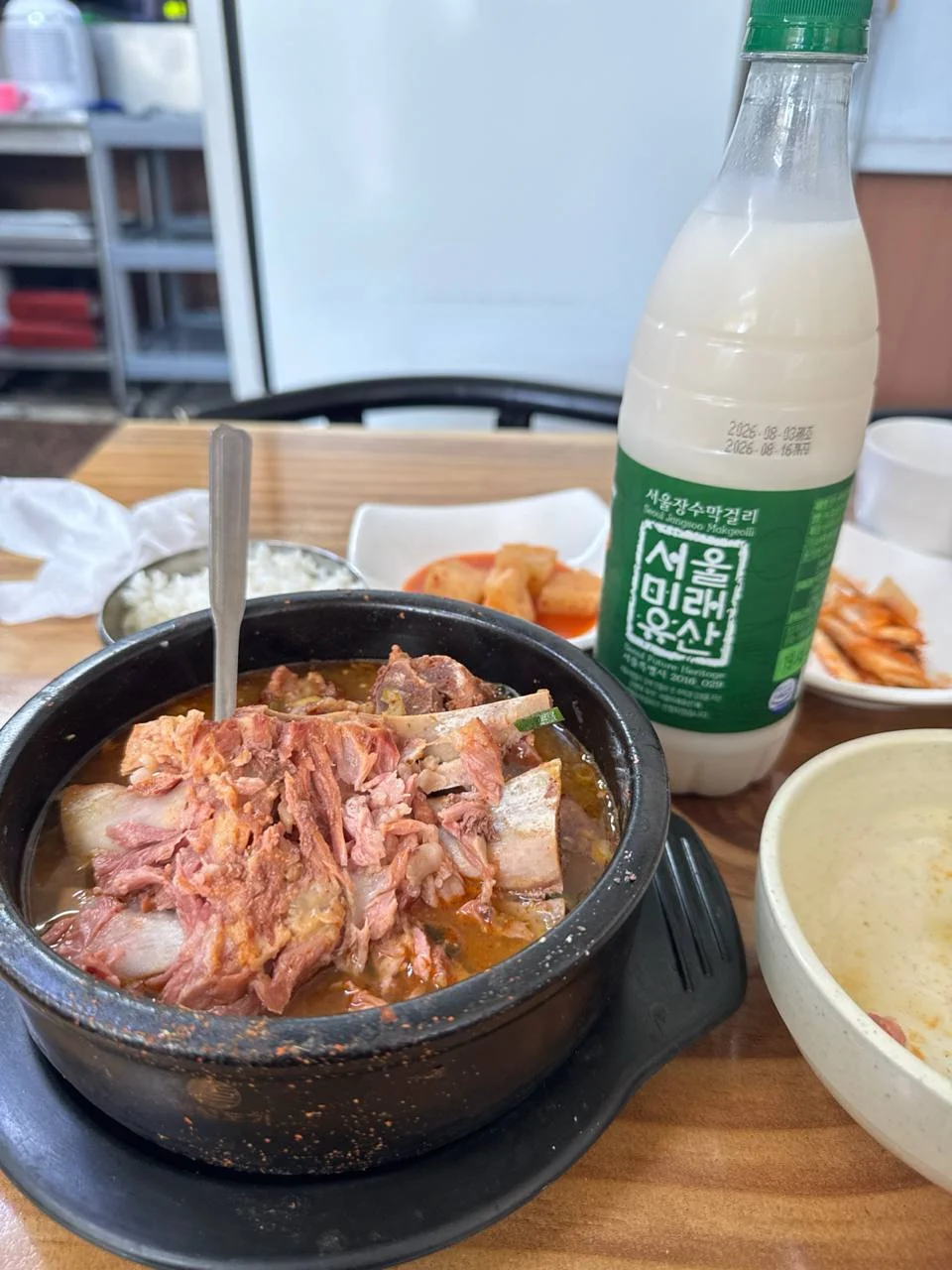 뼈해장국과 밥, 깍두기, 막걸리가 놓인 상차림